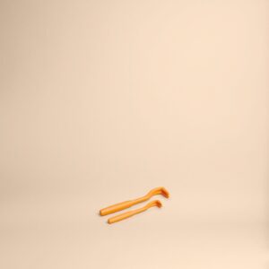 Deux brosses à dents orange sur fond beige