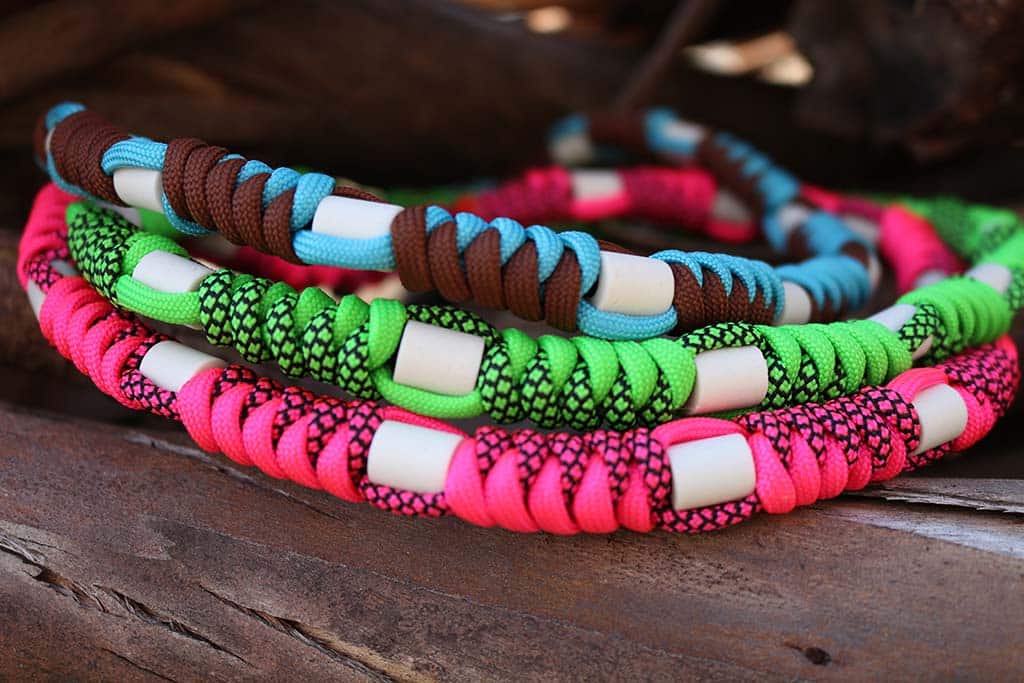 Collier avec perles en céramique fait en paracorde multicolores posés sur une table